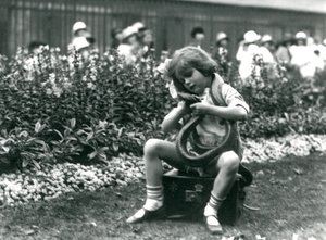 Nuori tyttö Betty pitelee itä-indigo-käärmettä istuessaan nahkaisen arkun päällä, Lontoon eläintarha, 1924 tekijältä Frederick William Bond