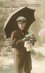 Komea, hyvin pukeutunut poika seisoo lumessa sateenvarjon kanssa (värikuva) tekijältä French Photographer