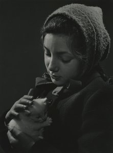 Tyttö pitää valkoista kissanpentua sylissään. 1950-luvun alku
