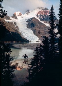 Yksinäinen hevonen ja ratsastaja pohtivat Kanadan korkeimman huipun juurella sijaitsevaa järveä. Mount Robson... tekijältä James L Stanfield