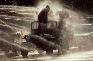 Ihmisiä suihkutetaan vesijuhlassa buddhalaisen uudenvuoden aikana. Mandalay, Burma. tekijältä James L Stanfield