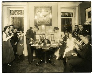Alice Foote MacDougal viihdyttämässä ryhmää merimiehiä pienessä asunnossaan Old Warissa, Greenwich Villagessa, New Yorkissa, Yhdysvalloissa, n. 1917-18 (gelatiinihopeakuva)