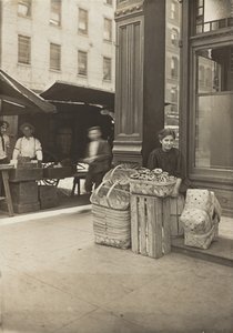 Lena Lochiavo - 11-vuotias korien ja rinkeleiden myyjä Sixth Streetin torilla saluunan sisäänkäynnin edessä, Cincinnati, Ohio tekijältä Lewis Wickes Hine