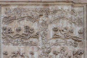 Naamah opettaa lasta lukemaan ja Tubal-cain lyö kelloja vasaralla; Enos, Sethin poika piirtää kompassilla, Genesiksen tarinat, Lorenzo Maitanin (ennen 1275-1330) bareljeefit, ensimmäinen pilari, Orvieton katedraalin sivujulkisivu, Umbria, Italia