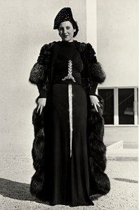 Malli iltapuvussa, jonka on luonut italialainen couture house "Dragoni". Artikkelin fontissa on räikeä, miekan muotoinen paljetekoriste. Hattu ja turkispäällystakki täydentävät kokonaisuuden. (m/w kuva)