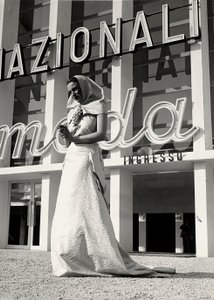 Malli hääpuvussa, jonka on luonut couture house "Lamma". Tuotteelle on ominaista luostaristyylinen päähine, jota pitää kaulassa rypäletertun muodossa oleva näyttävä neula. (m/w kuva) tekijältä Luis Bogino