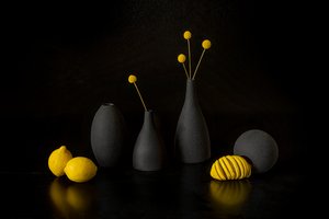 Keltaisia sitruunoita, mustia maljakoita