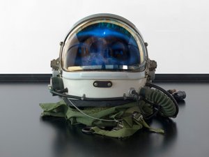 Alpha Omega, 2016 (Lasi, LCD-näyttö, mediasoitin, kopio kallosta, avaruuskypärä, puu) tekijältä Mat Collishaw
