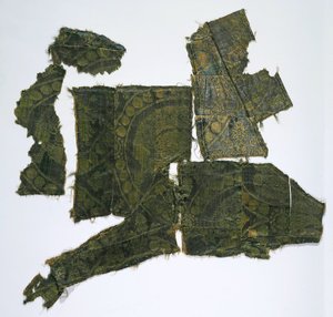 Fragmentteja kaftaanista, joka on päällystetty silkkikankaalla, jossa on senmurv-kuvio. Moshchevaya Balka hautaus M tekijältä Medieval Culture of the North Caucasian