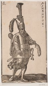 Soldat dempeus, girat cap al costat dret de la imatge; tocat amb plomall vertical molt alt; a la mà esquerra, un llaç amb grans plomes als dos extrems; a la mà dreta, una fletxa; a l