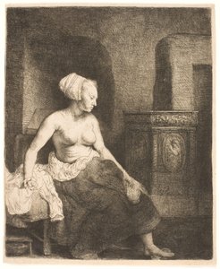 Nainen istuu puolipukeutuneena lieden vieressä tekijältä Rembrandt van Rijn