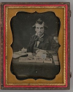 Nimetön muotokuva istuvasta miehestä pitelemässä dagerrotyyppiä ja sivellintä, 1865. tekijältä Samuel J. Miller