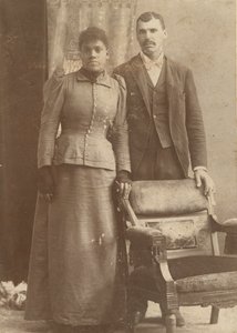 Valokuva afroamerikkalaisparista seisomassa tuolin takana, n. 1890. tekijältä Schmitz Studio