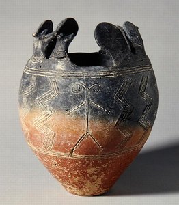 Punaiseksi kiillotettu astiakulho, jossa eläimen pää ja aurinkokiekon kiinnikkeet, Vounous, Kypros, hauta 91, 2500-2075 eKr. (savi)