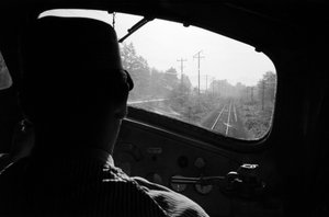 Näkymä raiteille dieselveturin ohjaamosta veturinkuljettajan kanssa, Tyynenmeren luoteisranta. tekijältä Ted Spiegel