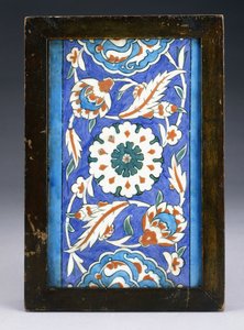 Iznik-reunuslaatta, jonka keskellä on kukkapää rullaavan palmetin ja vehreän viiniköynnöksen välissä, n. 1570 (keraaminen) tekijältä Turkish School