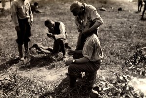 Itävaltalaiset vangit ensimmäisen maailmansodan aikana Bagnaria Arsassa, Udinen, Italiassa; etualalla sotilas ajelee toverinsa, 02.04.1916 (b/w kuva)