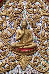 20151102, Vang Vieng, Laos : Kultareliefit koristeltu sisäänkäynti. Opetusbuddha kuvaa tiettyä hetkeä Buddhan elämässä, nimittäin ensimmäistä saarnaa, jonka Buddha piti saavutettuaan valaistumisen tekijältä Unbekannt