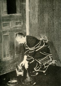 John Nevil Maskelyne esittää henkikaapin illuusion, v. 1910. tekijältä Unbekannt