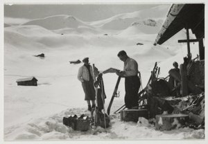 Hiihtäjät mökin ulkopuolella, n. 1930 tekijältä Unbekannt