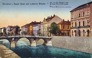 Postikortti, joka kuvaa Sarajevon, Appel Quayn ja Lateinerin sillan, arkkiherttua Franz-Ferdinandin ja hänen vaimonsa Sophien salamurhan 28. kesäkuuta 1914, n. 1920 tekijältä Unbekannt Unbekannt