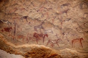 Kalliotaide, esihistoria: Kalliomaalaus karjaryhmästä ja monivärisistä hahmoista (paimenet ja jousimiehet) koristeellisessa suojissa Uweinatin vuoristossa, Sudanissa. Ajanjakso 8000-3000 vuotta eKr. Valokuvaus tekijältä Unbekannt