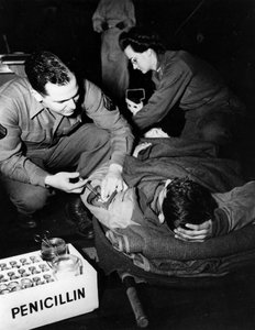 Toinen maailmansota (1939-1945) – Toinen maailmansota (WWII tai WW2): Luxemburg helmikuu 1945: Yhdysvaltain armeijan evakuointisairaalassa lääkäri (sairaanhoitaja) antaa penisilliiniä loukkaantuneelle sotilaalle tartunnan välttämiseksi, kun taas sairaanhoi tekijältä Unbekannt