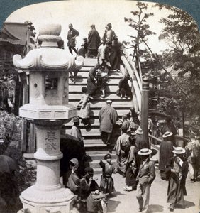 Palvojat ylittävät puolipyöreän sillan Kameidon temppeliin, katsovat pohjoiseen, Tokioon, Japaniin, tekijältä Underwood and Underwood