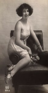Nuori nainen poseeraa alushameessaan, istuu nojatuolissa. tekijältä Unknown photographer