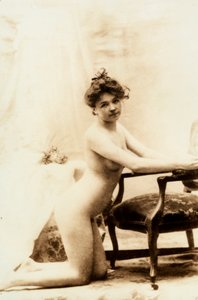 Alaston muotokuva nuoresta naisesta, joka polvistuu pienen nojatuolin edessä. tekijältä Unknown photographer