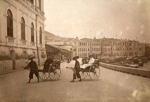Kaksi miestä kuljettaa riksalla Hongkongissa. tekijältä Unknown photographer