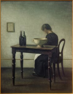 Nainen istuu pöydän takana tekijältä Vilhelm Hammershoi