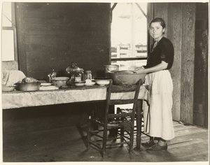 [Elizabeth Tengle keittiön pöydässä]/[Paralee Ricketts työskentelee keittiössä] tekijältä Walker Evans
