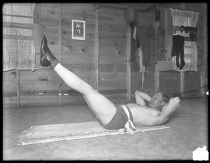 Englantilainen nyrkkeilijä William Thomas Wells (Bombardier Billy Wells), poseeraa harjoitushousuissa jalkoja nostamassa, n. 1911