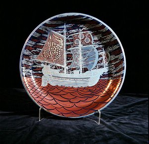 Hopeakiiltävä laturi, jossa galleon purjehtii punaisella kiiltävällä merellä (keraaminen) tekijältä William de Morgan