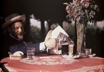 Frank Eugene istuu pöydän ääressä tekijältä Alfred Stieglitz