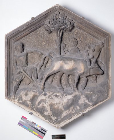 The Art of Agriculture, kuusikulmainen koristeellinen kohokuviolaatta sarjasta, joka kuvaa taiteen ja tieteiden harjoittajia, mahdollisesti perustuen Giotton (n. 1266-1337) n. 1334-1348 (marmori) suunnitelmiin tekijältä Andrea Pisano