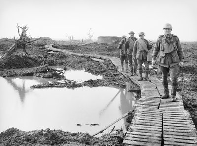 Neljä australialaista sotilasta kävelemässä pitkospuurataa pitkin Tokiossa, lähellä Zonnebekeä, Ypres-sektorilla, yli osan maasta, jonka australialaiset vangitsivat kolmannen taistelun taistelussa. tekijältä Australian Photographer