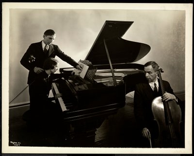 Sokea nainen, neiti Harding, pianon ääressä opettamassa kahta sokeaa miestä viulun ja sellon soittamisessa, 1936 (hopeagelatiiniprintti) tekijältä Byron Company