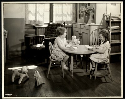 Kaksi sokeaa näkövammaista tyttöä syömässä pienen pöydän ääressä nuken kanssa New York Association for the Blindissa, 111 East 59th Street, New York, 1933 (hopeagelatiiniprintti) tekijältä Byron Company