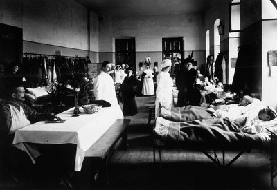 Koristeltu salonki sairaalassa, jossa on sotahaavoittuneita, lääkäreitä, Punaisen Ristin sairaanhoitajia ja vierailijoita (m/v kuva) tekijältä Carlo Wulz