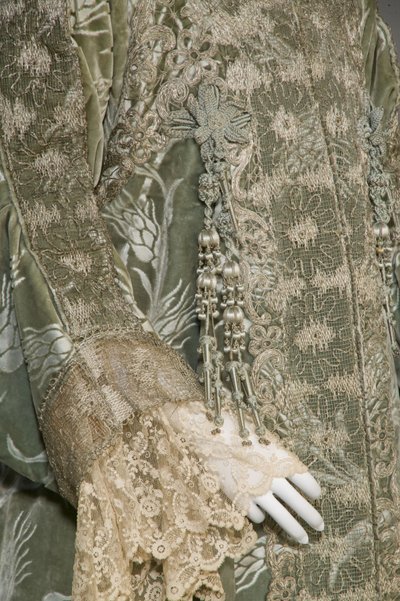 Bertha Palmerin iltatakki, n. 1902 (yksityiskohta hihasta). Silkkisatiini leikatulla sametilla vehnäkuviolla, metallinen lankapitsi, silkkimetalliset tupsut. Worth, Pariisi. tekijältä Charles Frederick Worth