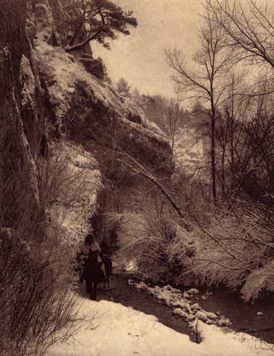 Kallion ohittaminen, talvimaisema. Apsaroke-intiaanit ratsastamassa kalliota pitkin lumessa Pryor-joella, Montanassa. Kuva otettu Edward S. Curtisin (1868-1952) Pohjois-Amerikan intiaaneja käsittelevän tietosanakirjan osasta 4, jossa on Theon esipuhe tekijältä Edward Sheriff Curtis