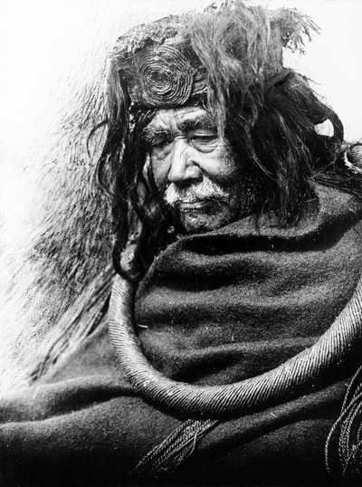 Hamatsa, Nakoaktok c. 1910 Puolipitkä muotokuva Nakoaktok-miehestä vasemmalle päin, yllään setrijuuren seremoniallinen silmukka. tekijältä Edward Sheriff Curtis