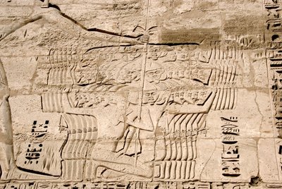 Egyptiläinen antiikki: yksityiskohta ensimmäisen pylonin reliefeistä, jotka edustavat Ramses III:n vihollisten merikansoihin kuuluvien taistelijoiden vangitsemista. Ramses III:n hautaustemppeli (1187-1156 eKr.). Luxor, Medinet Habou, Egypti tekijältä Egyptian 20th Dynasty