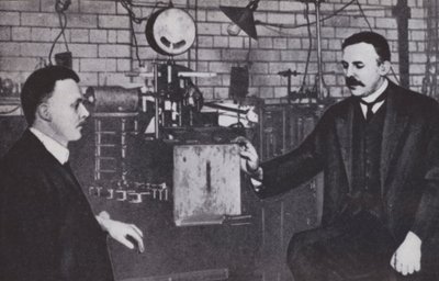 Ernest Rutherford (vasemmalla) ja Hans Geiger Manchesterin yliopiston fysiikan laboratoriossa (s/w-kuva). tekijältä English Photographer