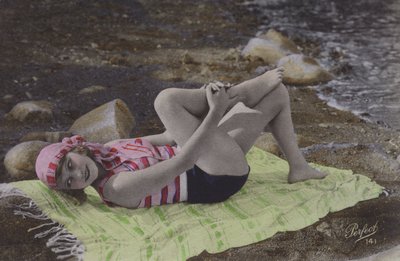 Tyttö makaa pyyhkeellä rannalla (värillinen kuva) tekijältä English Photographer