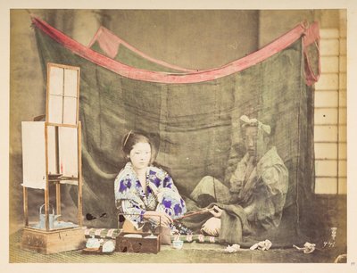 Japanilainen pariskunta vapaa-ajalla, Ateljeekuva nuoresta japanilaisesta naisesta, joka istuu teenkeittoesine ympärillään ja ojentaa piippua takanaan istuvalle mieshahmolle, jota suojaa pellava hyttysverkko,   Valokuvaaja: Tuntematon  Lucasin kokoelma: tekijältä English Photographer