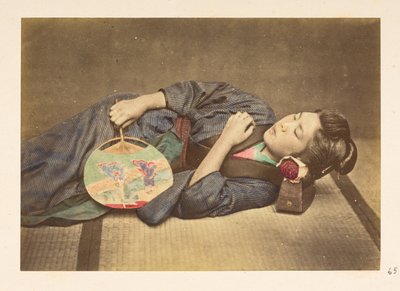 mulher japonesa dormindo, Retrato de estúdio de três quartos de uma jovem japonesa dormindo, segurando um leque na mão direita e com a cabeça apoiada em um travesseiro de madeira,   Fotógrafo: Desconhecido  Lucas Collection: Registro fotográfico do mundo f tekijältä English Photographer