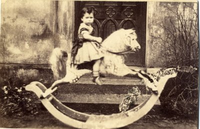 Pikkutyttö suurella keinuhevosella puutarhassa, 1860-luku (albumiprintti) tekijältä English Photographer